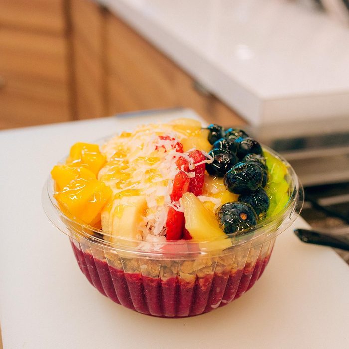 Bowl topped with mango, coconut and strawberry